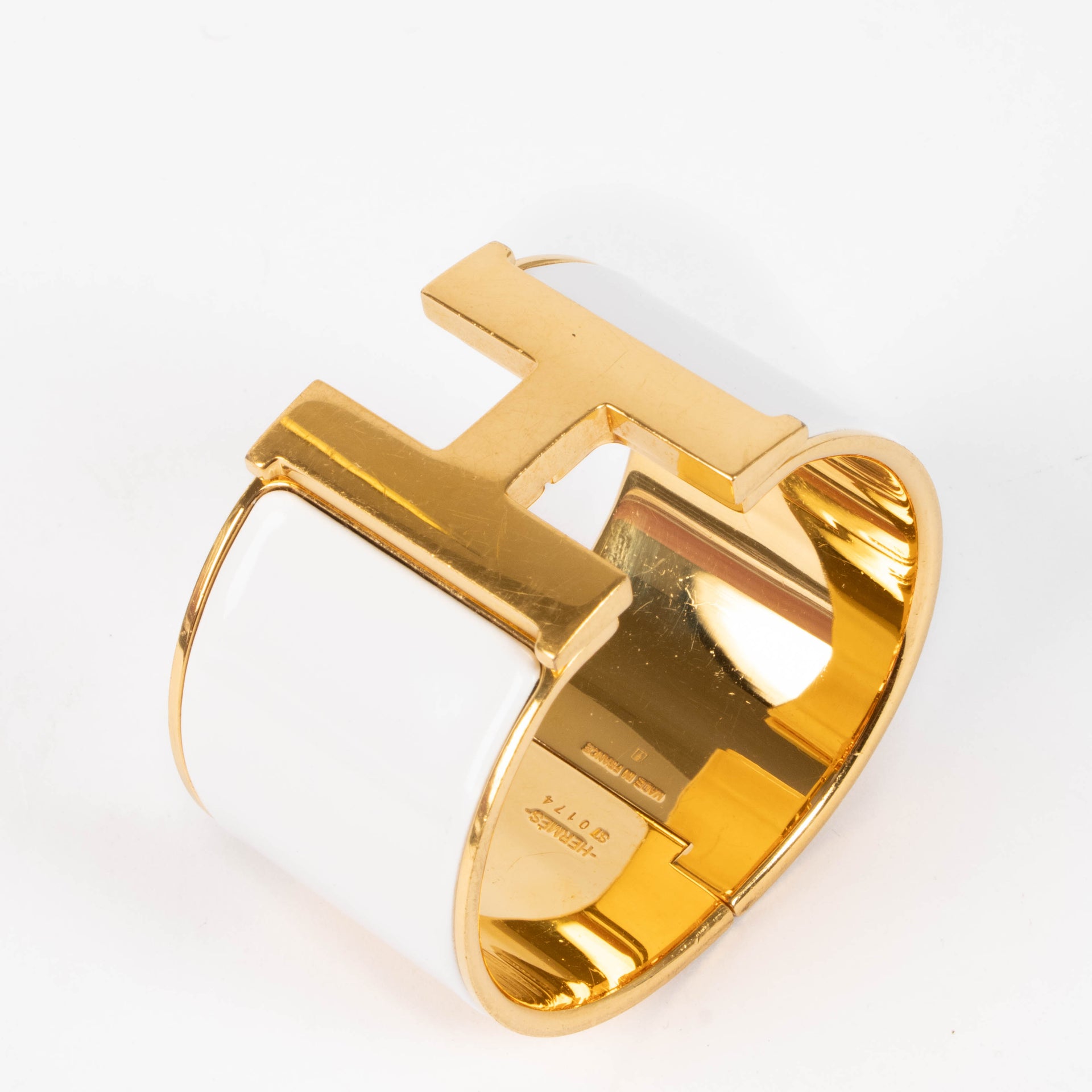 shop this authentic Hermes White/Gold Extra Wide Clic H Bracelet pre-loved on Labellov.com