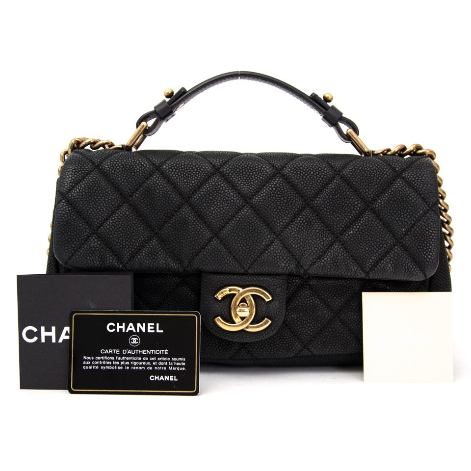 Chanel flap bag with grained black calfskin leather. Gold-toned chanel sign. Online vintage bags at Labellov.