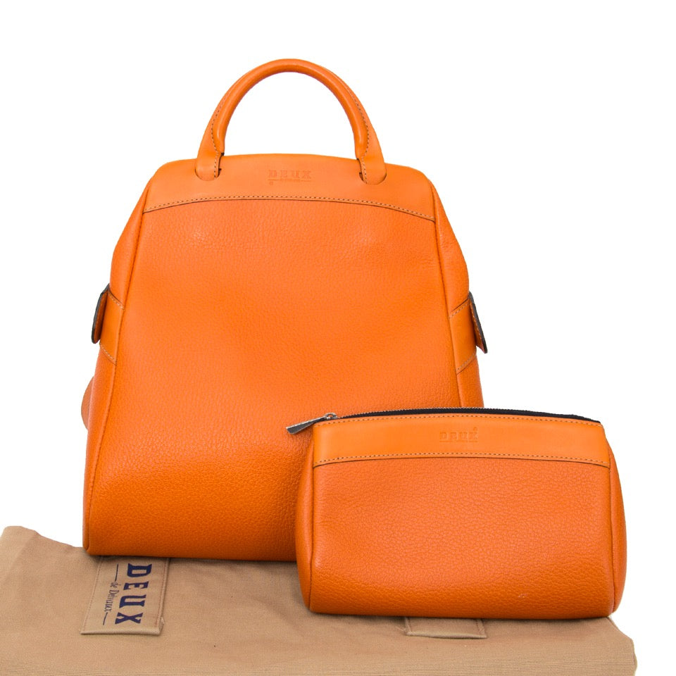 Authentieke Delvaux Deux Oranje rugzak voor de juiste prijs bij LabelLOV vintage webshop. Delvaux Deux Orange Backpack. Veilig online winkelen. Luxe, vintage, mode. Antwerpen, België.