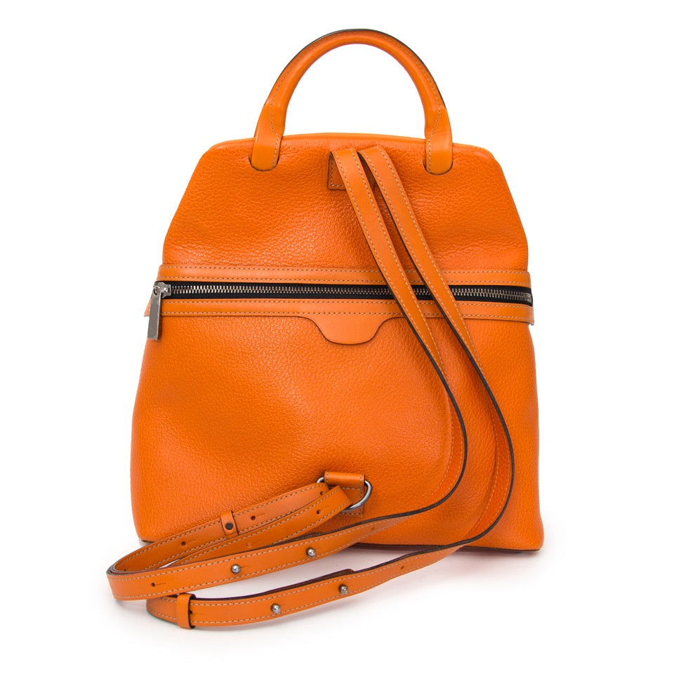 Authentieke Delvaux Deux Oranje rugzak voor de juiste prijs bij LabelLOV vintage webshop. Delvaux Deux Orange Backpack. Veilig online winkelen. Luxe, vintage, mode. Antwerpen, België.