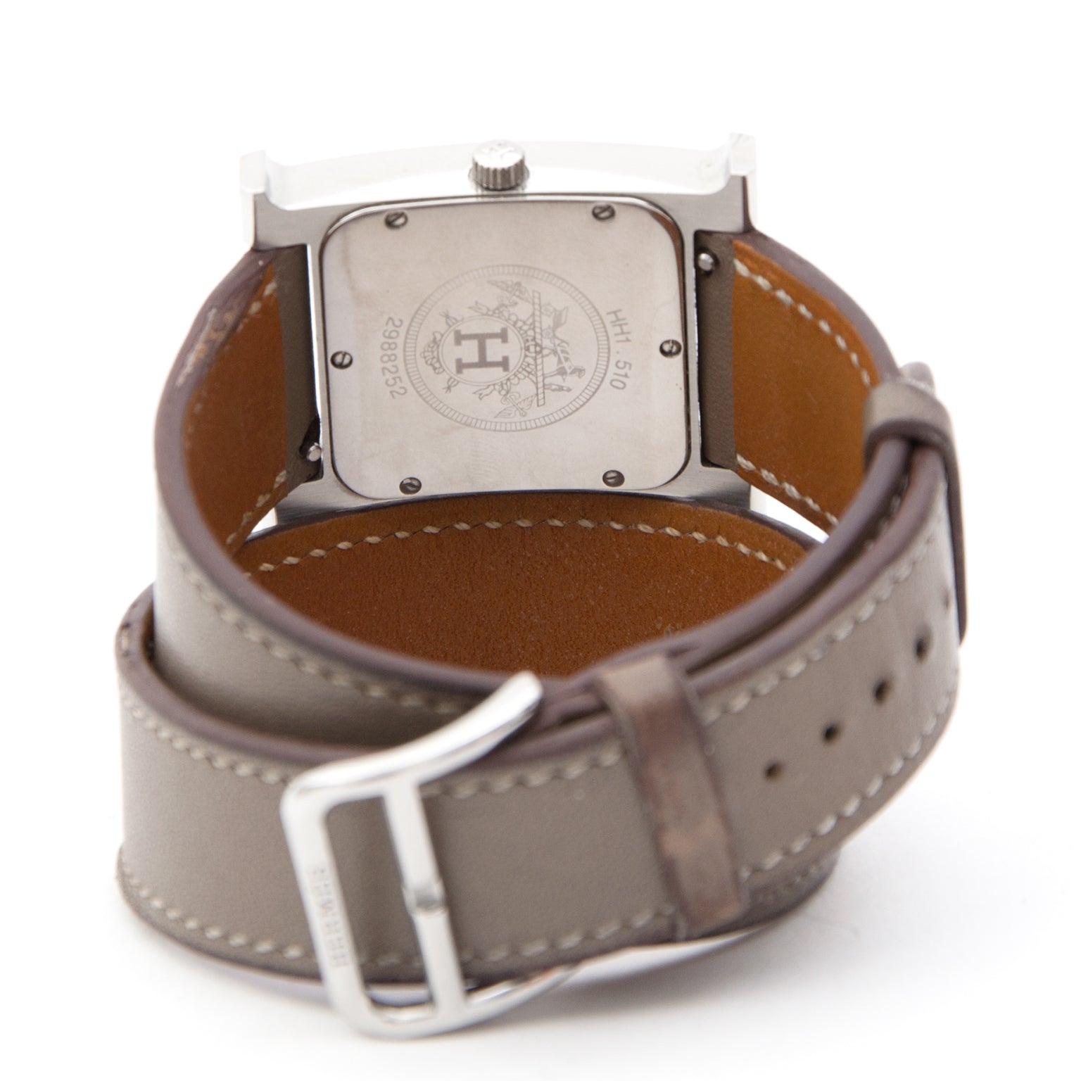 This exquisite time piece is the famous Hermès Heure H, with Double Tour bracelet in Taupe and Paladium framework. Comes in its original box with receipt of purchase.