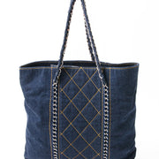This is a Chanel tote in blue denim with contrast ochre stitching. Silver-tone chain hardware.