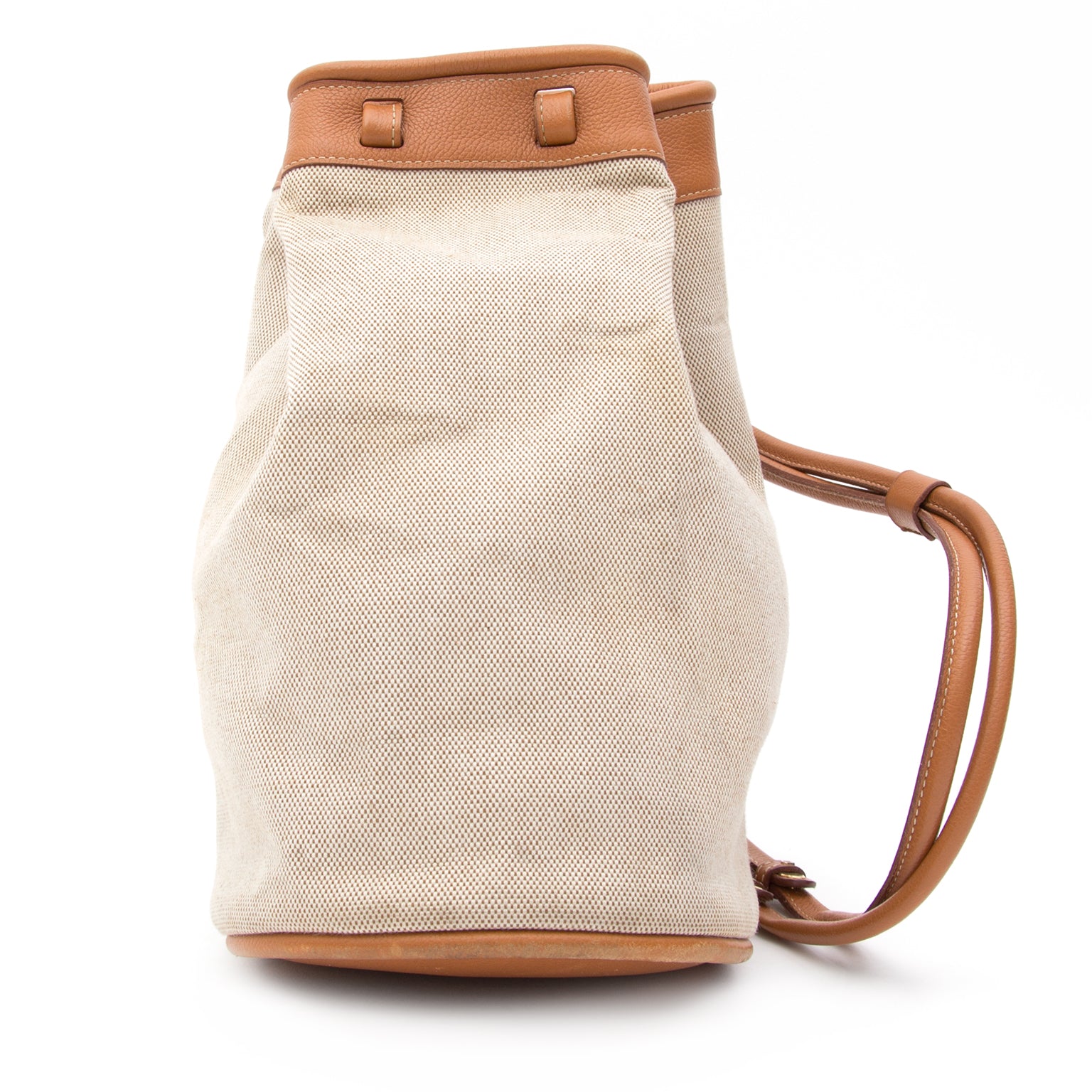 Fun and practical carry-all Delvaux bucket bag made from sand colored woven canvas with grained cognac base and top trimming. Gold-tone closure clasp and interior keychain.
