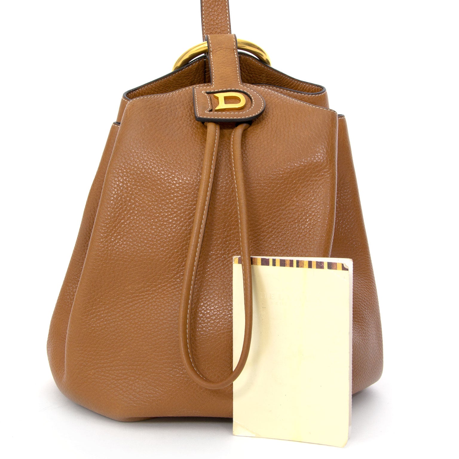A Delvaux 90s classic: the Rose des vents drawstring bucket bag. Here in sturdy yet supple cognac colored calfskin with tonal hardware. Its elegant shape and contrast stitching have not gone out of style, quite the opposite is true!