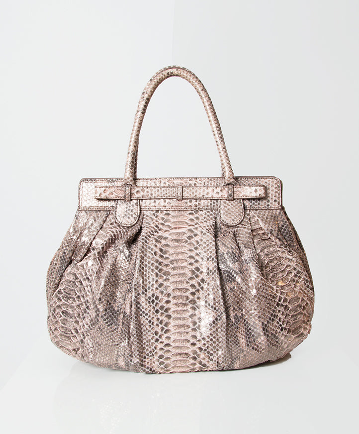 Zagliani’s iconic design, the Puffy by Zagliani, takes on new refinement for spring in old rose metallic python. Signature delicate pleats and a curved handle infuse feminine allure into the voluminous shape that can carry all the day’s essentials.