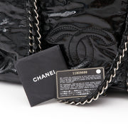 This Chanel tote has a high-gloss patent leather exterior and metallic interior lining. Double 'CC' stitched logo on the front. The braided leather & chain straps and embedded chain detailing for added dramatic effect. Comes with booklet and authenticity