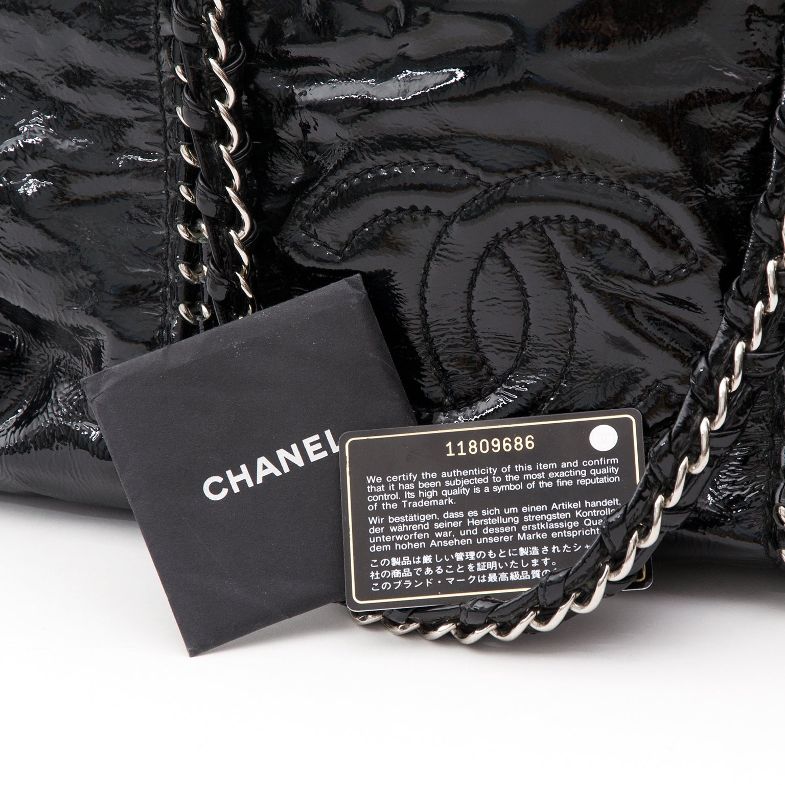This Chanel tote has a high-gloss patent leather exterior and metallic interior lining. Double 'CC' stitched logo on the front. The braided leather & chain straps and embedded chain detailing for added dramatic effect. Comes with booklet and authenticity