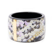 This is a storebought Christian Dior bangle bracelet in acryl with lilac black and white pearl theme. Both print and glossy finish reference antique Oriental lacquered woodwork. This is an eyecatching piece that works equally well on day or evening wear.
