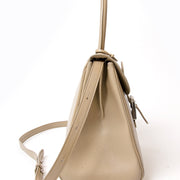 This Delvaux Brillant MM is a top handle bag with attachable shoulder strap in 'Plume' or greige colored 'Jumping' type calfskin. Gold hardware throughout.