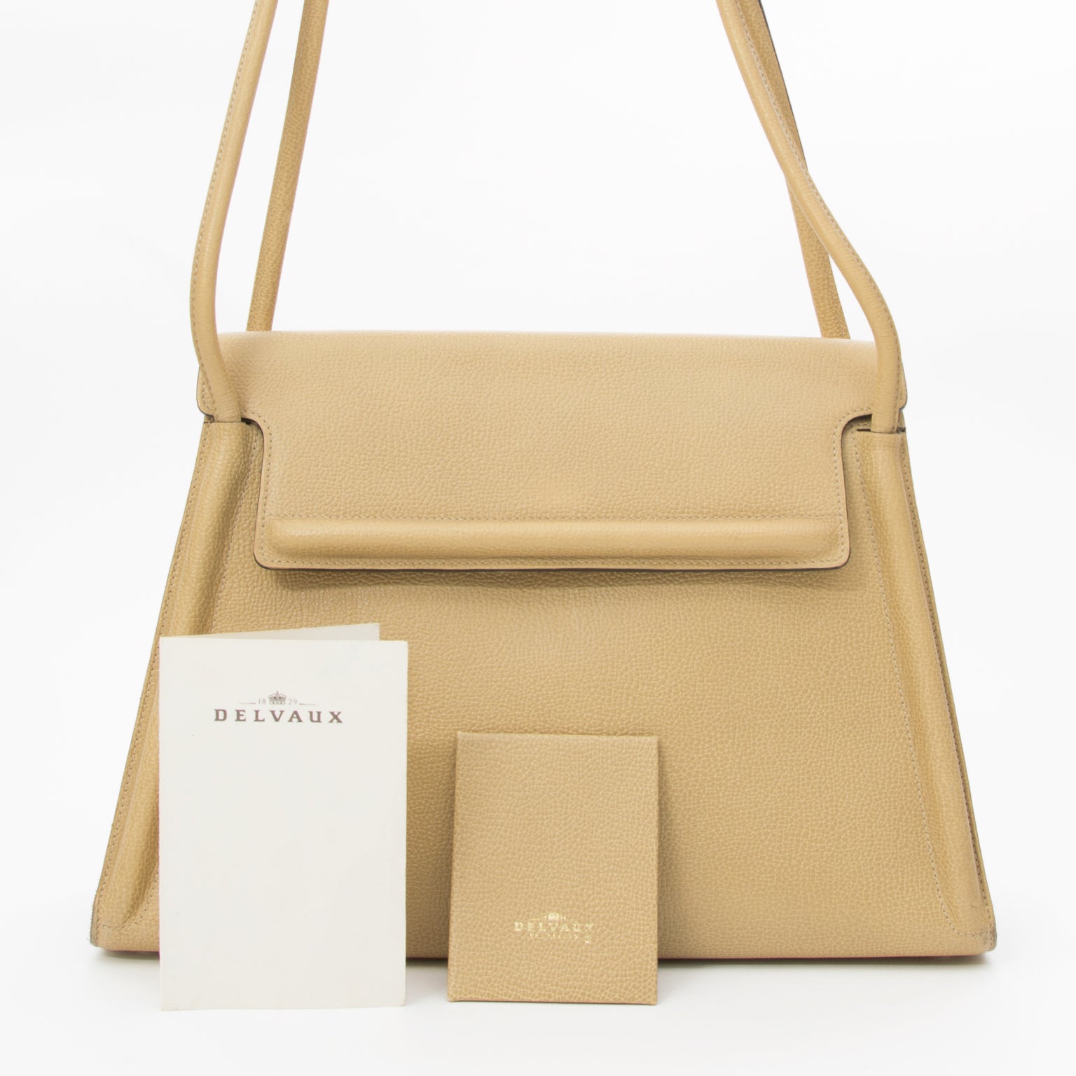 Delvaux Sand Ecru Vintage Shoulder Bag This authentic vintage shoulder bag by Delvaux features double straps and a flap closure. The interior of the bag features two compartments, one zipper compartment, a pen pocket an keychain holder. Leather finished m