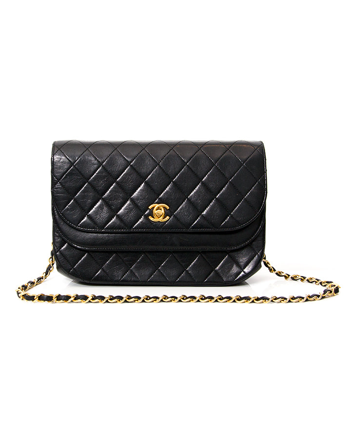 Chanel Black Quilted Flap Bag. A lovely Chanel flap bag with quilted lambskin exterior, gold and leather chain, double 'C' turnlock. Two compartments with burgundy ribbed silk doublure. Interior flap features stitched double 'C'. Comes with original flan