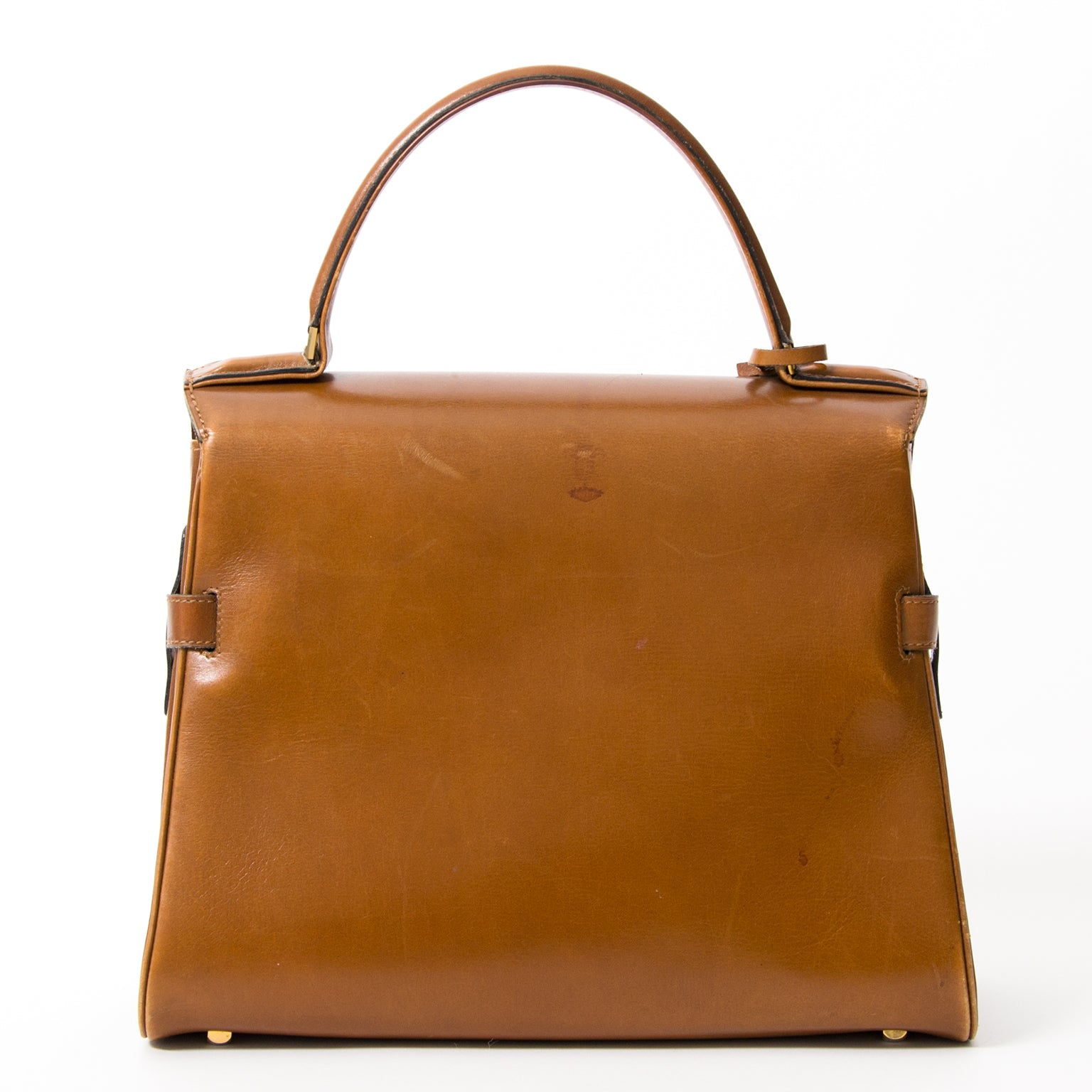 The famous Delvaux Tempete features goldtoned hardware and four studs on the bottom for better protection. The suede interior in the main compartment includes a small pocket for easy storage.