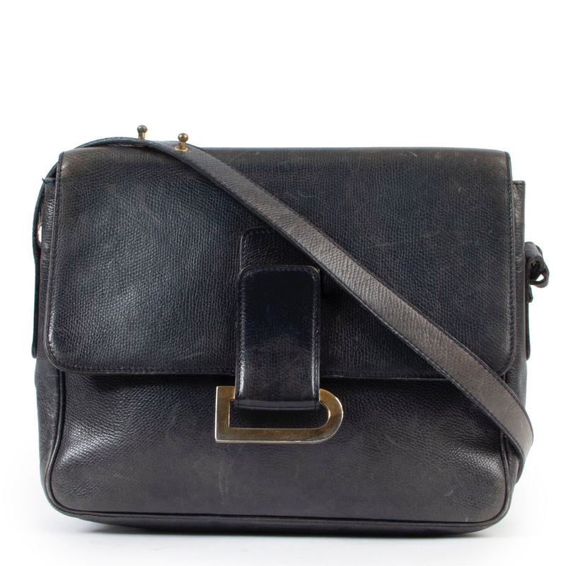 Delvaux Blue Poirier Crossbody Bag We absolutely adore this Poirer handbag. Designed by Delvaux, the oldest fine leather goods house in the world. The handbag is crafted in dark blue leather and finished with a gold toned D in the front. The front f