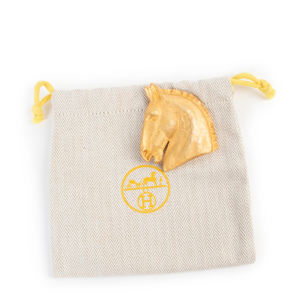 By an authentic second hand Hermès Horse Head Brooch at Labellov