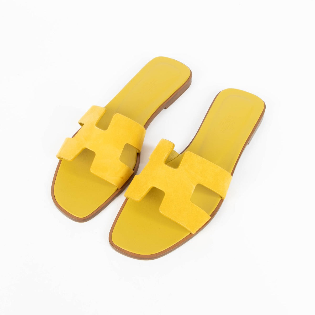 Are you looking for an authentic designer accessory? We buy and sell your preloved and brand new Hermès Yellow Suede Oran Sandals.
