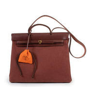 Shop safe online at Labellov in Antwerp this 100% authentic second hand Hermès Burgundy and Beige Retourne Top Handle Herbag
