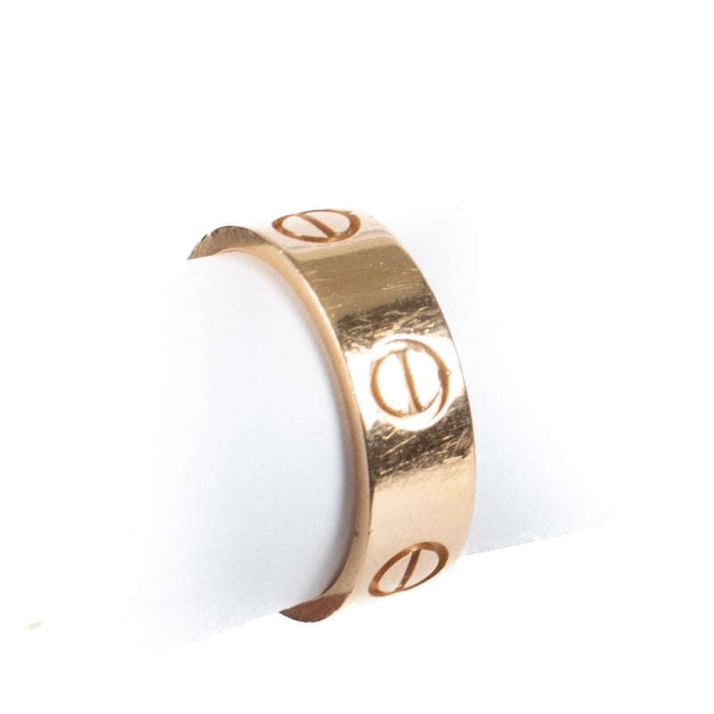 Authentic Cartier Love Ring in 18K rose gold, showing gentle wear and light scratches, complete with original box and certificate at Labellov.com.