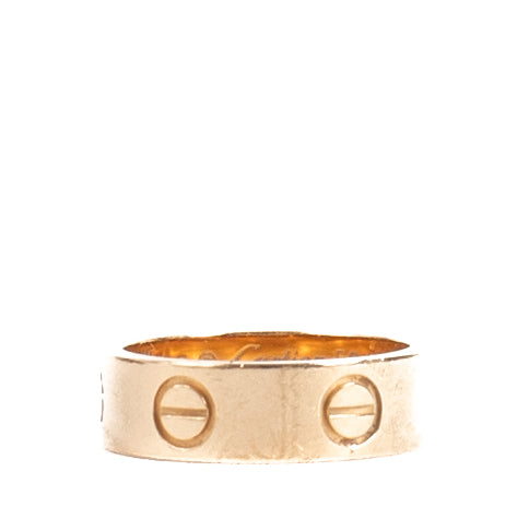 Authentic Cartier Love Ring in 18K rose gold, showing gentle wear and light scratches, complete with original box and certificate at Labellov.com.