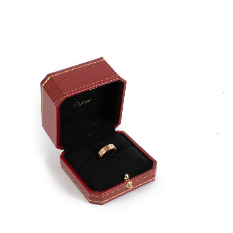 Authentic Cartier Love Ring in 18K rose gold, showing gentle wear and light scratches, complete with original box and certificate at Labellov.com.