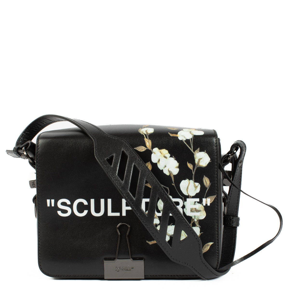 Black leather shoulder bag with cotton flower print, Off-White cut-out strap, 'SCULPTURE' text print, magnetic closure, and binder clip detail at the front. Includes one black shoulder strap. Shop now on Labellov.com.