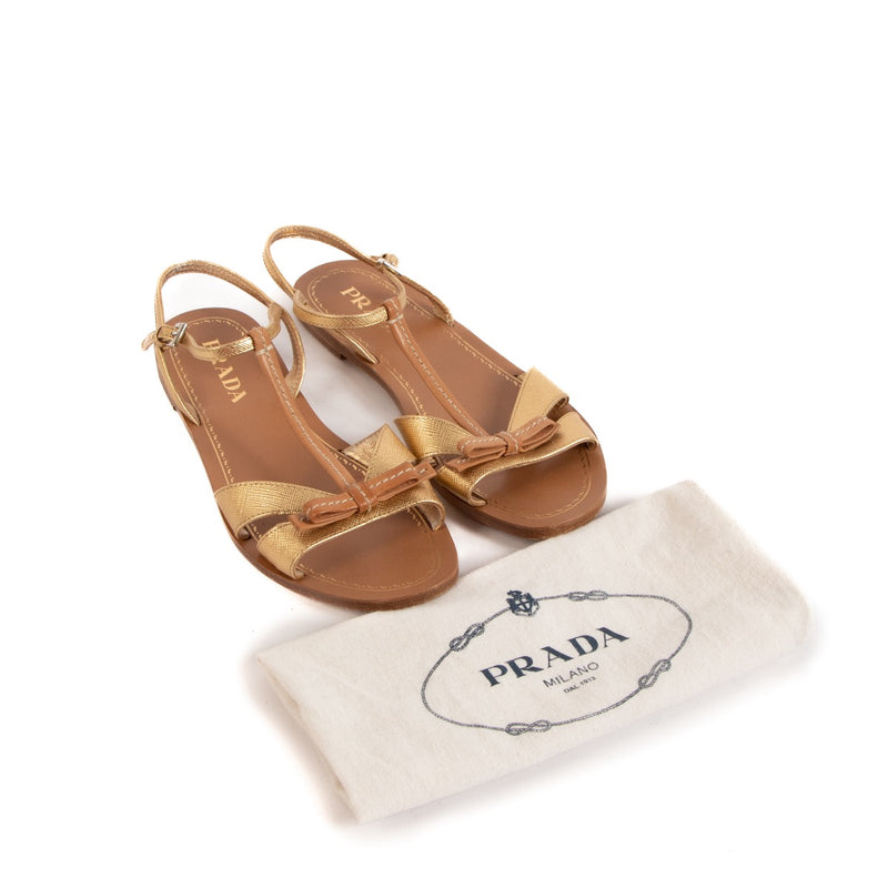 Prada Gold & Tan Leather Bow Sandals - size 36 for the best price at Labellov secondhand luxury in Antwerp. We buy and sell your authentic designer bags online.