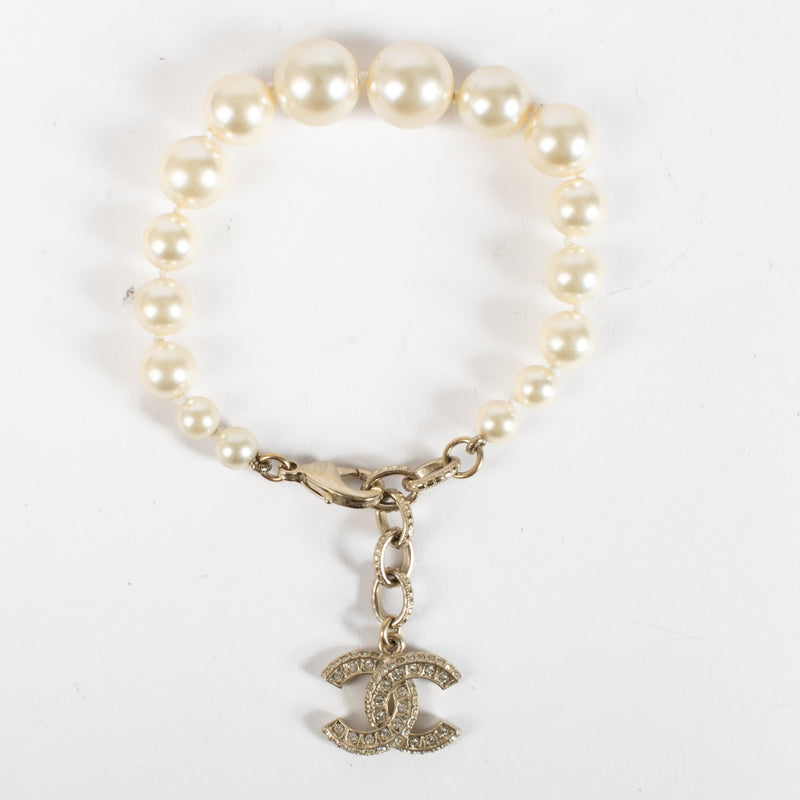 Shop the authentic Chanel Pearl Bracelet with crystal CC charm in champagne-gold hardware at Labellov.com.