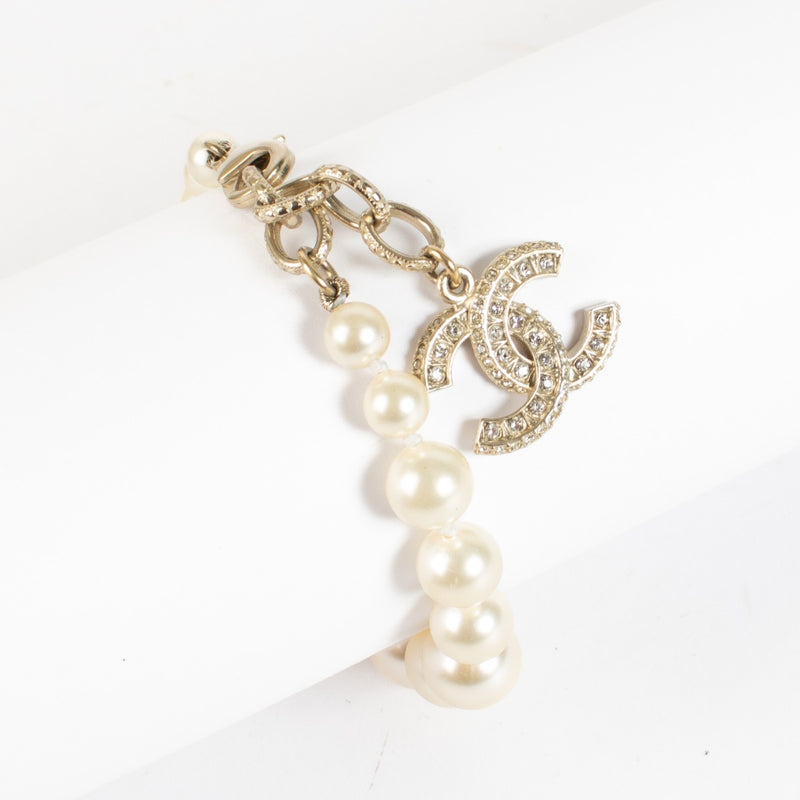 Shop the authentic Chanel Pearl Bracelet with crystal CC charm in champagne-gold hardware at Labellov.com.