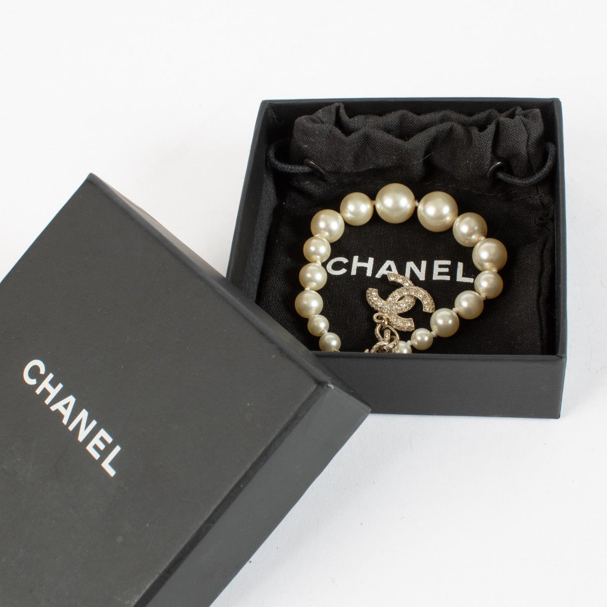 Shop the authentic Chanel Pearl Bracelet with crystal CC charm in champagne-gold hardware at Labellov.com.