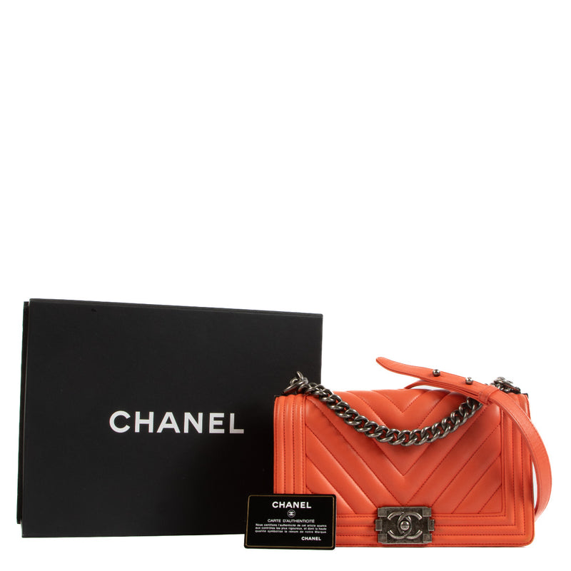 We buy and sell your authentic Chanel Coral Red Chevron Boy Medium Shoulder Bag for the best price at Labellov secondhand luxury in Antwerp