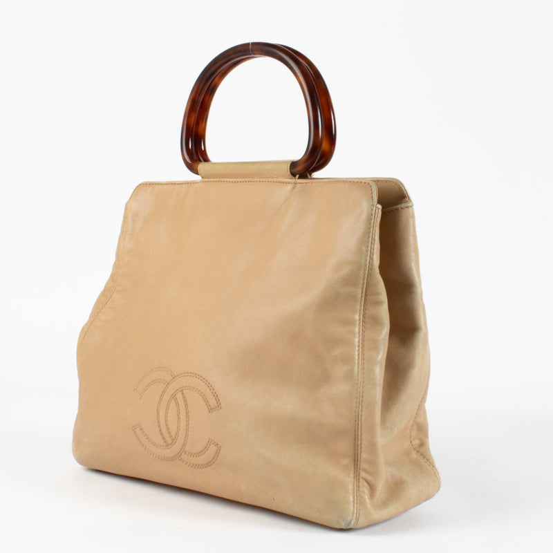 The exterior leather shows signs of wear, including light creasing, softening, and small marks typical of vintage lambskin. The interior fabric lining has some discoloration and light stains, consistent with age.