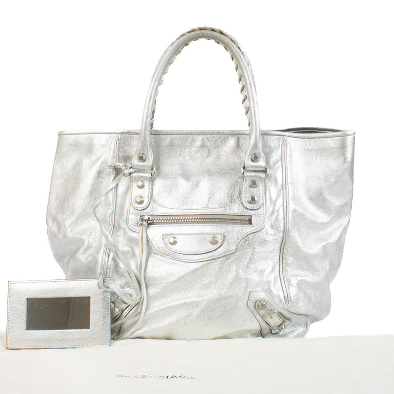 We buy and sell your preloved and brand new designer bags for the best price. Wij kopen en verkopen aan de beste prijs bij Labellov Balenciaga Metallic Silver Small Sunday Tote Bag.