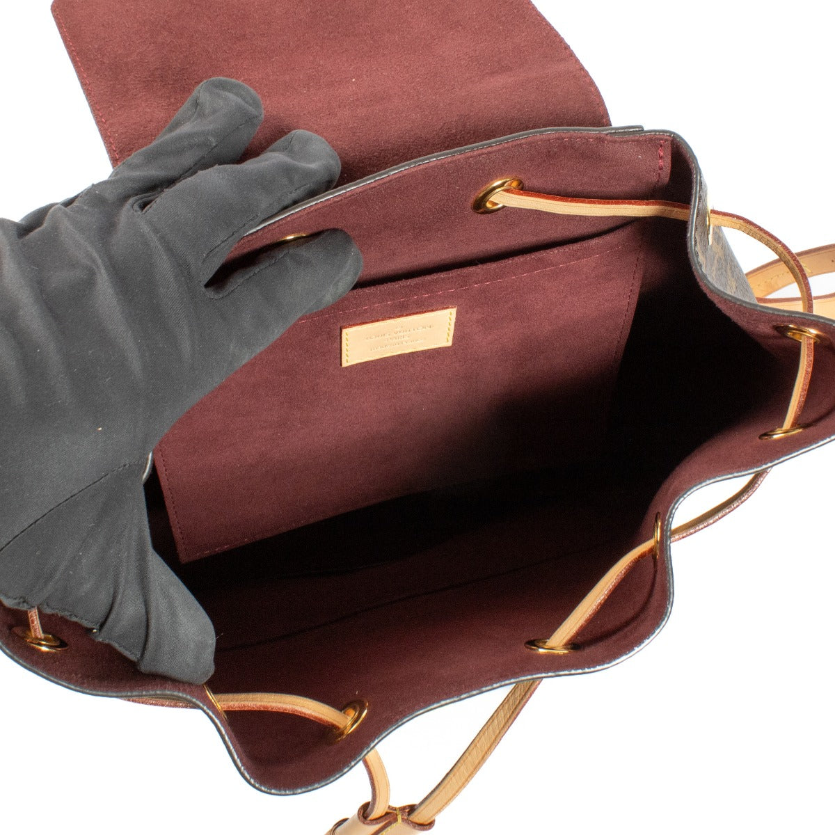 The Louis Vuitton Monogram Montsouris Backpack features the iconic LV monogram canvas with natural leather trim, a drawstring closure with a buckle flap, and adjustable leather straps for comfort. Its spacious interior and front zip pocket offer practical