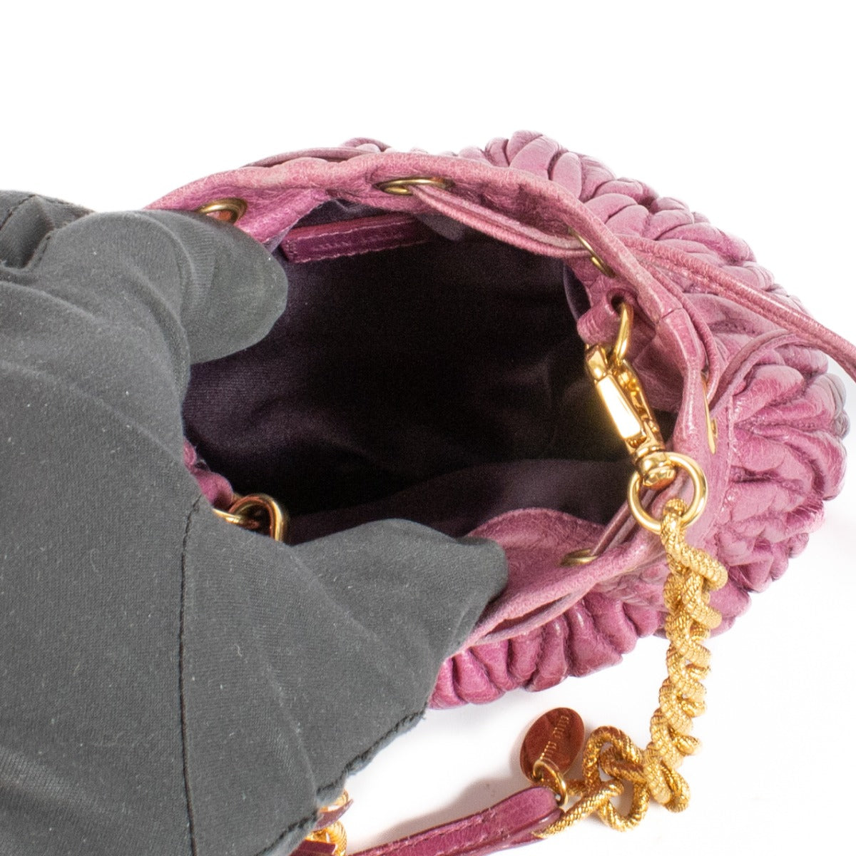 The Miu Miu Purple Crossbody is a small, pouch-shaped bag in a rich purple hue, featuring gold hardware for a luxurious touch. Perfect for carrying essentials in style. Buy now on Labellov.com