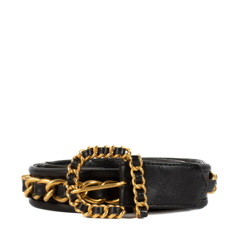 The Chanel 93A Black Chain On Leather Belt is a striking vintage piece from Chanel’s 1993 Fall collection, showcasing the brand’s timeless ability to blend luxurious materials with bold design. Crafted from smooth black leather, this belt features a promi