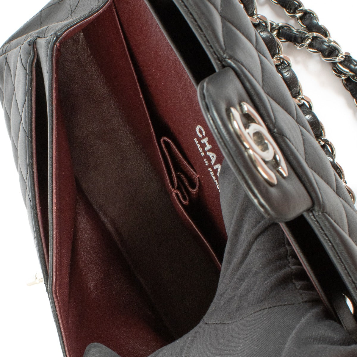 Chanel Black Lambskin Small Classic Bag with silver-tone hardware and turnlock closure, showcasing a smooth, elegant finish. Shop now on Labellov.com.