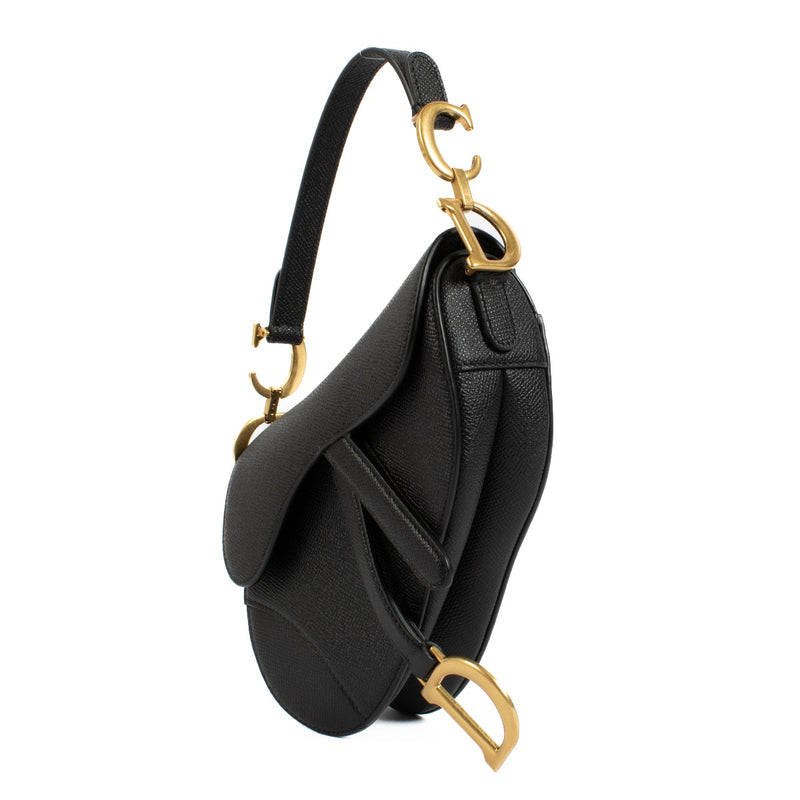 The Dior Black Leather Mini Saddle Bag is a timeless, compact luxury piece in very good condition. Crafted from black leather with gold-tone hardware, it features minimal signs of wear and a versatile strap for effortless styling. Shop now on Labellov.com