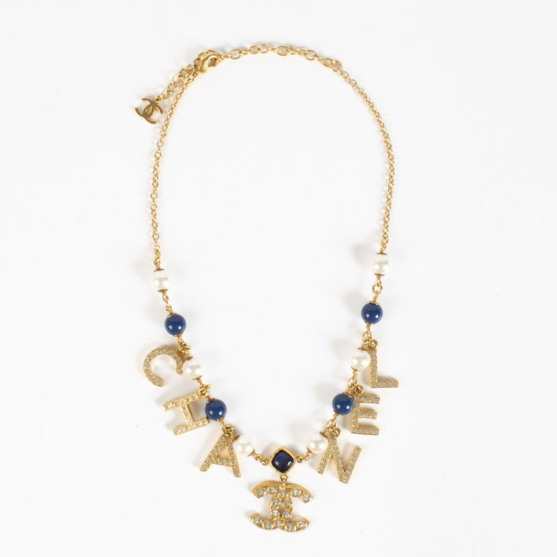Authentic Chanel gold-tone letter necklace with crystals, pearls and CC logo charm at Labellov.com.