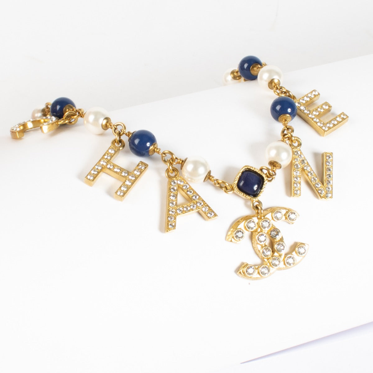 Authentic Chanel gold-tone letter necklace with crystals, pearls and CC logo charm at Labellov.com.