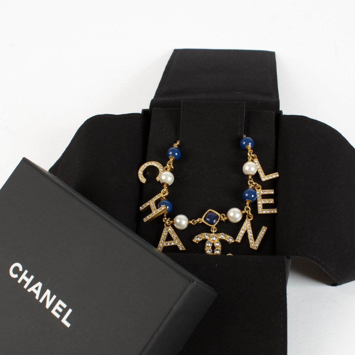 Authentic Chanel gold-tone letter necklace with crystals, pearls and CC logo charm at Labellov.com.