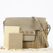 Close-up of Delvaux Malbec bag featuring beige canvas and leather trim, showcasing Belgian craftsmanship.