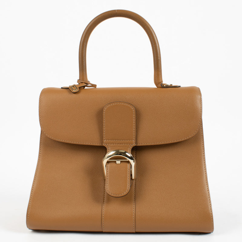 Delvaux Brillant MM Bag in cognac leather with gold buckle and top handle.