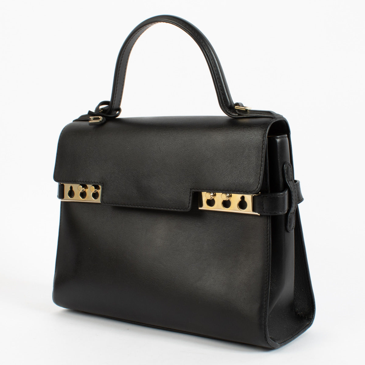 Side view -up of Delvaux Tempête MM showing clean flap, top handle, and polished hardware detail.
