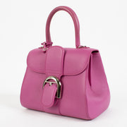 Side profile of heliotrope Delvaux bag with removable chain strap for versatile styling.