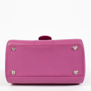 Lifestyle shot of Delvaux Heliotrope Brillant Mini styled with a monochrome outfit for a pop of color.