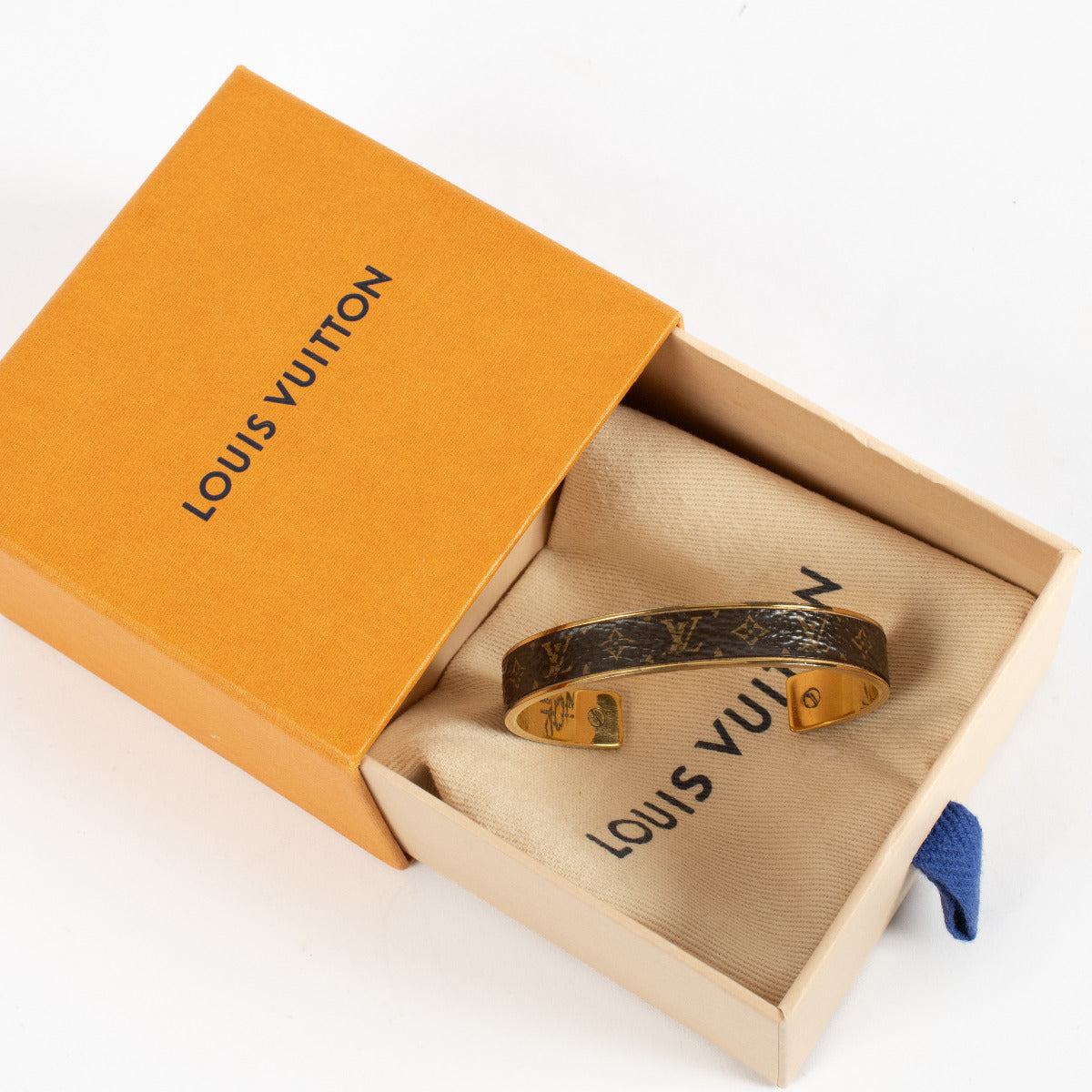 The slender cuff is crafted in polished gold‑tone brass and encircled by signature canvas or enamel adorned with the classic LV monogram motif. Handcrafted in Italy, this open‑style bracelet slips on effortlessly, radiating understated refinement with a m