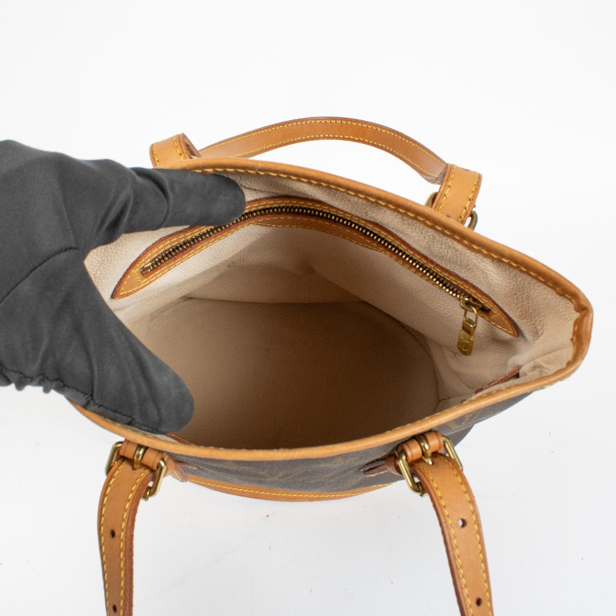 Authentic Louis Vuitton Petit Bucket bag in Monogram canvas with vachetta leather trim at Labellov.com