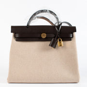 Effortlessly blending sporty sophistication with timeless Hermès craftsmanship, the Herbag Zip 31 Retourne is the epitome of understated luxury. This Hermès Herbag 31 features a structured top-handle silhouette crafted in durable Écru canvas with tonal Bé
