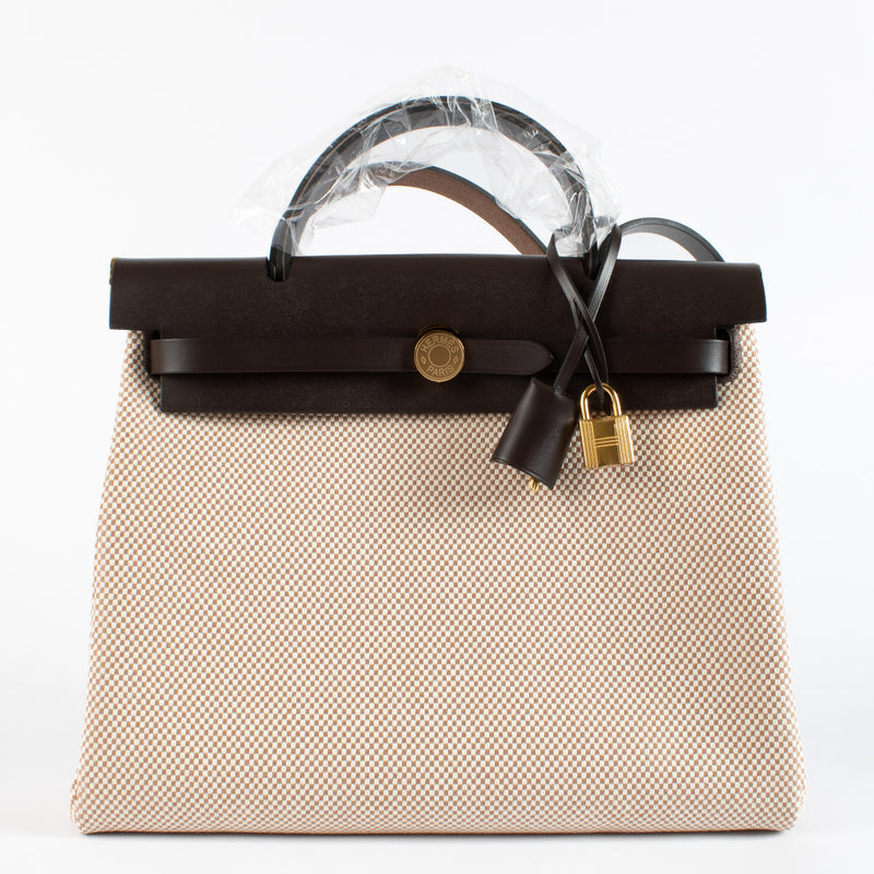 Effortlessly blending sporty sophistication with timeless Hermès craftsmanship, the Herbag Zip 31 Retourne is the epitome of understated luxury. This Hermès Herbag 31 features a structured top-handle silhouette crafted in durable Écru canvas with tonal Bé