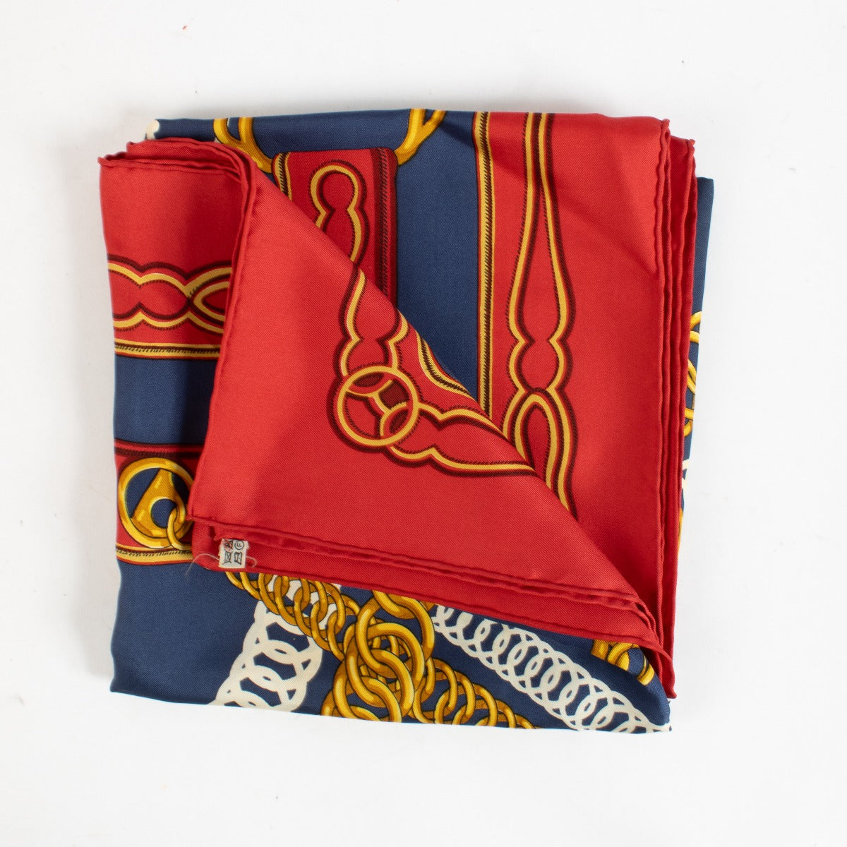 Are you looking for an authentic designer accessory? We buy and sell your preloved and brand new Hermès Red/Blue Maillons 90 Scarf.