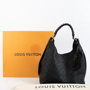 Louis Vuitton Carmel Hobo in black Mahina perforated calf leather with braided handle, silver-tone hardware and roomy interior. Shop now at Labellov.com